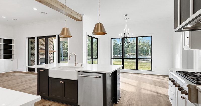 A nice kitchen island with a dishwasher and a nice sink. The sink is farmhouse in design.