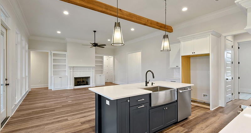 The nice gray is a pop of color in the kitchen. The house features hardwood floors and a nice white wall.