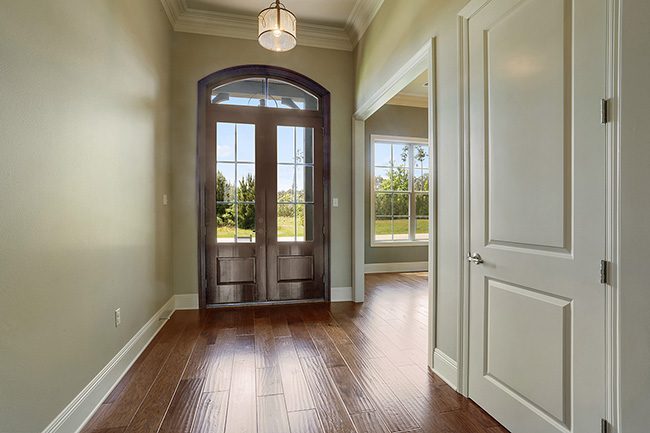 Grand front entry with double wooded doors.