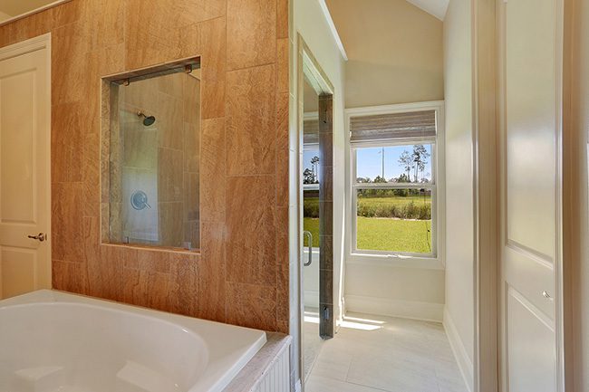 Open and airy master bath with a window in the shower.