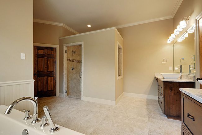 Spacious master bath with custom tile and double vanities. Tile floors and tiled shower give a clean look. Private separate water closet. Custom lighting in the large walk in shower.