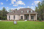 This custom home features dormers and a nice front porch. The yard is fully landscaped and the home is located close to New Orleans.