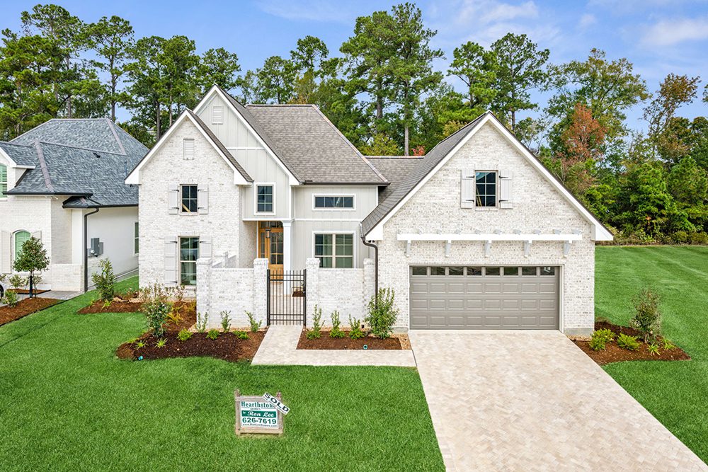 1-198 Maison du Lac Overview A stunning modern home with white brick and a pitched roof.