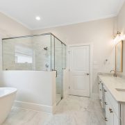 A pop of color is seen in this nuetral bathroom in the custom vanity mirrors.