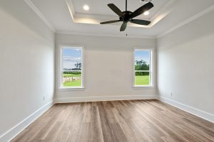 The master bedroom has nice rich hardwood floors and a custom ceiling fan. The trey ceiling is accented by recessed lighting.