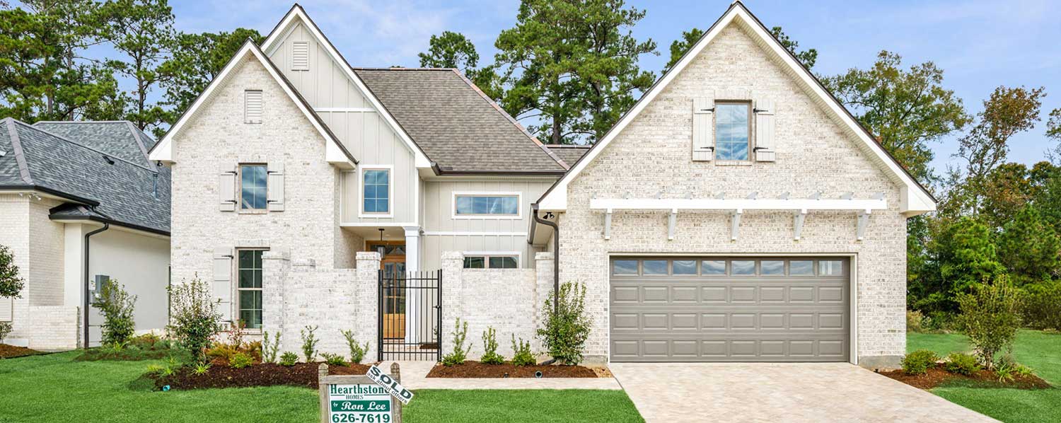 The well-manicured landscaping with fresh mulch and greenery enhances the home’s curb appeal. A “SOLD” sign from Hearthstone Homes and Ron Lee confirms this modern gem has already found its proud new owners.