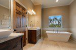 Master bath with custom tub and picture window. Large soaking tub where you can relax and view the perfect scenery. Custom lighting over the tub and walk in shower.