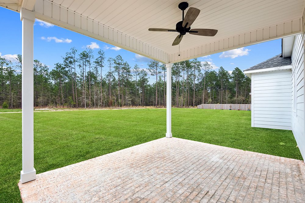 22-603 Night Heron Covered Private Patio The kitchen includes a farmhouse sink, white cabinetry, and modern pendant lights, all bathed in natural light from the expansive windows.
