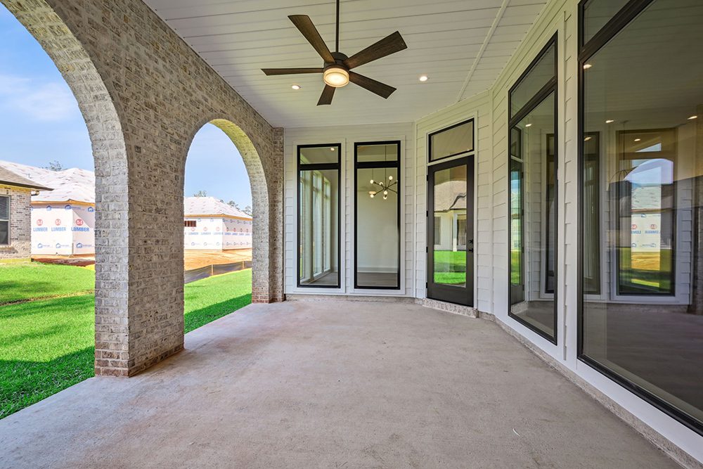 24-5040 Twin River Brick Arches on Covered Porch The neutral palette and elegant finishes make it a versatile extension of the home’s living space.