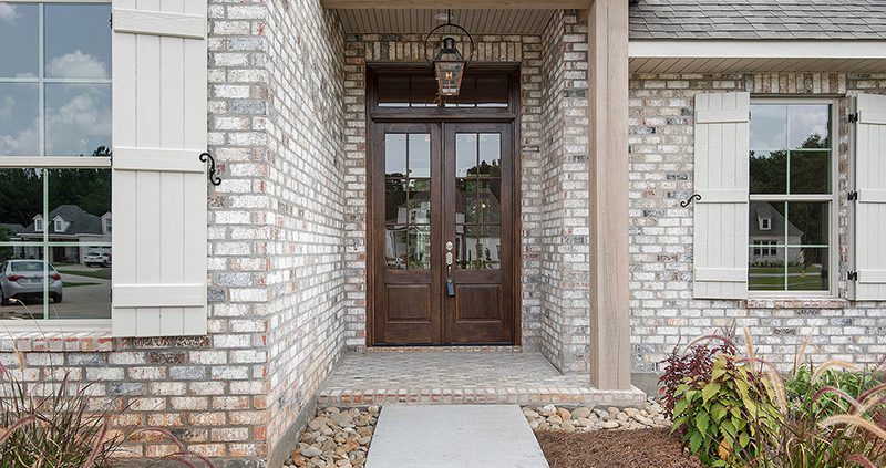The front entry of this home is accented by a nice covered area, custom lighting and professional landscaping.