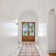 The patterned tile inlay creates a striking runway effect, bordered by marble-look tile that adds a refined, luxurious contrast.