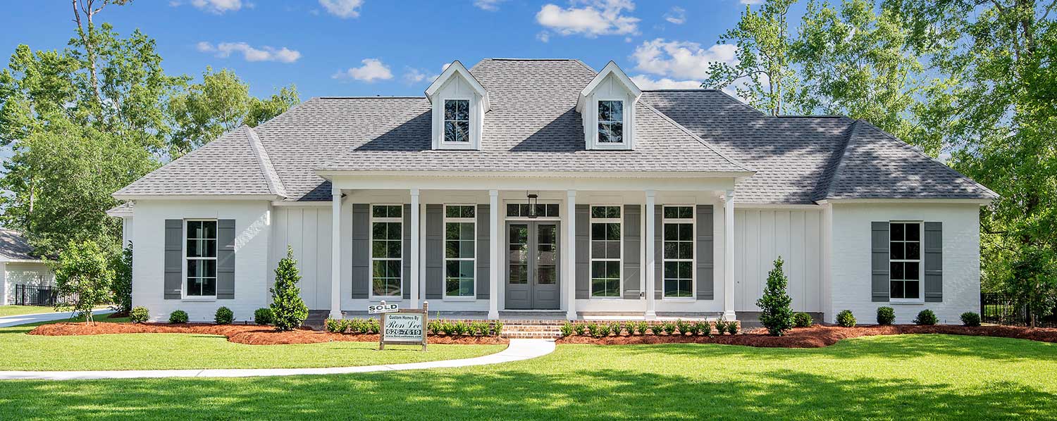 Meticulously landscaped with a curved walkway, manicured lawn, and neat garden beds, this home balances sophistication and warmth. A sign near the entrance confirms it has already been sold.