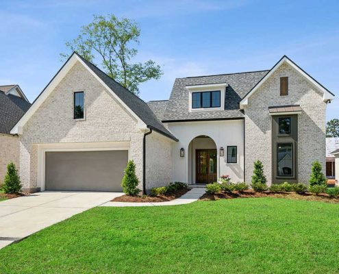 A dormer window above the entry adds charm and natural light to the upper level, while the oversized two-car garage provides ample space and convenience. The home’s thoughtful design balances traditional warmth with contemporary elegance.