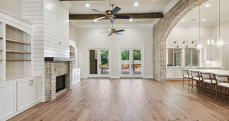 Wood ceiling beams and the brick accent archway help define the spaces in this open floor plan concept.
