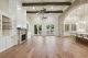 Wood ceiling beams and the brick accent archway help define the spaces in this open floor plan concept.
